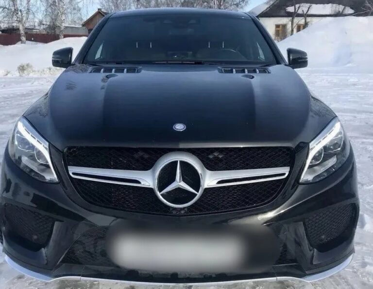 Автомобиль марки Mercedes-Benz представительского класса на фоне здания суда или отдела полиции.