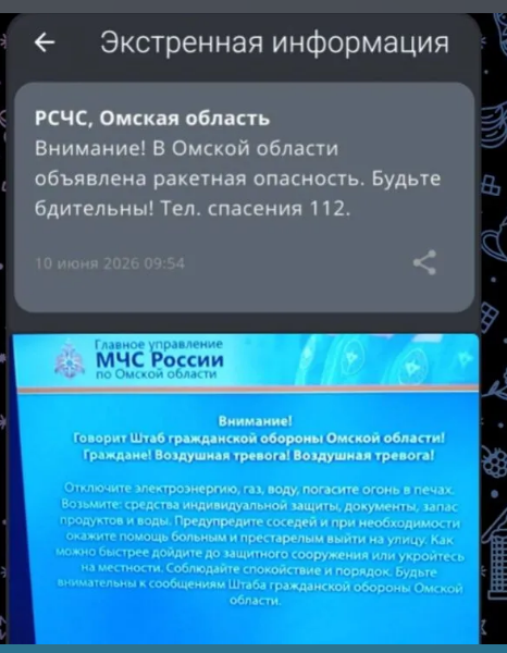 Городской экран на центральной улице Омска, транслирующий экстренное СМС-оповещение МЧС России о фиксации беспилотной опасности 10 июня 2026 года.