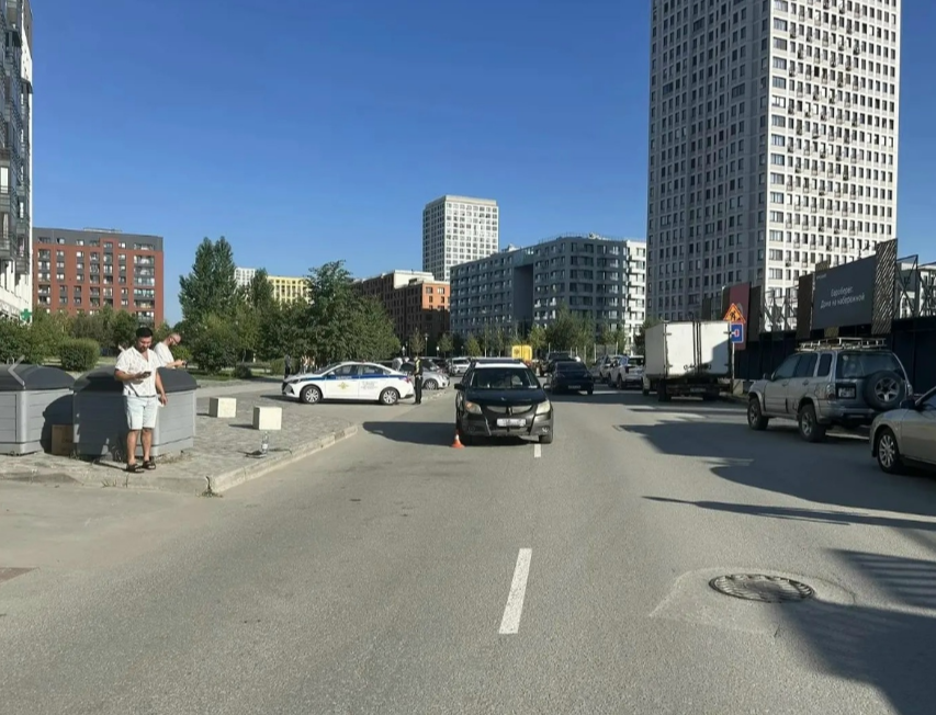 Патрульный автомобиль дорожно-патрульной службы с включенными проблесковыми маячками работает на месте совершения дорожно-транспортного происшествия в черте города.