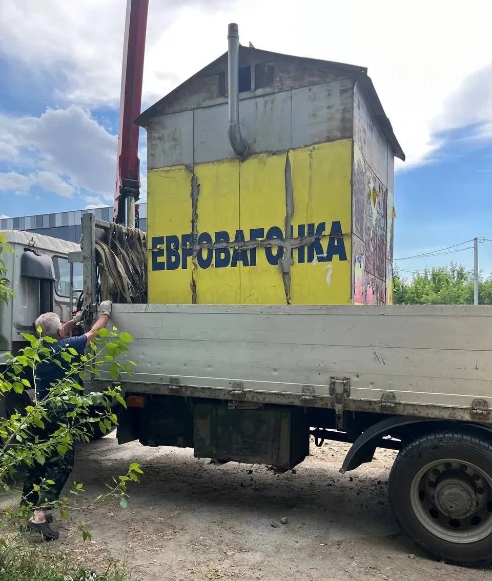 Спецтехника муниципального учреждения осуществляет погрузку демонтированного металлического контейнера в Заельцовском районе Новосибирска 4 июля 2026 года.