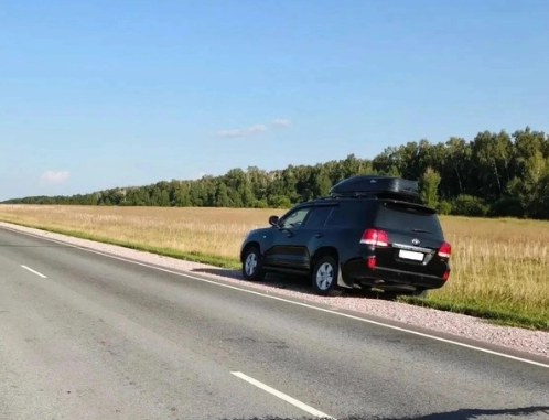 Патрульный автомобиль Госавтоинспекции с включенными спецсигналами на загородной трассе в вечернее время