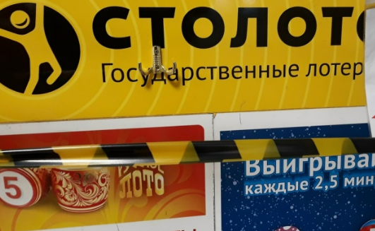 Продавец стирает защитный слой на лотерейных билетах на рабочем месте